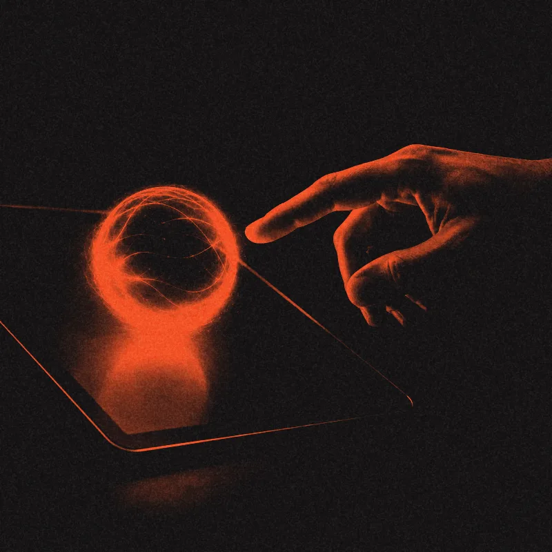 A fingertip reaching toward a glowing orb hovering above a tablet